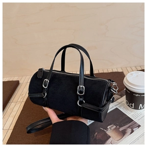 Detail of black suede cylinder bag with silver hardware and smooth leather handles
