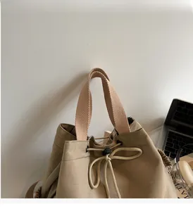 Detailed side view of khaki canvas drawstring bag with sturdy handles and toggles