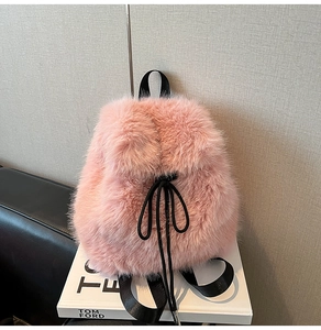 Detailed view of pink plush backpack texture with black drawstring and metal tips