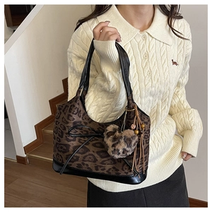 Close-up of leopard print shoulder bag with black leather trim and plush heart pendant