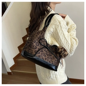 Detail of leopard print tote bag with plush texture and black ribbon bow detail