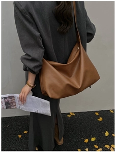 Deep tan soft leather tote bag styled with an autumn coat for a stylish commute look