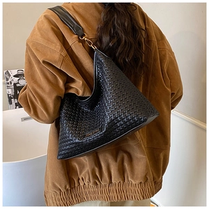 Detail of black woven texture shoulder bag with brand logo and metallic hardware