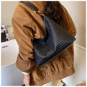 Close-up of black woven hobo bag with gold hardware and intricate braided leather texture