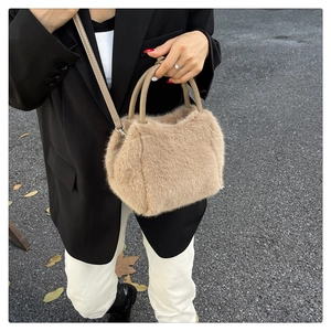 Close-up of soft beige faux fur handbag with PU leather handles and adjustable shoulder strap