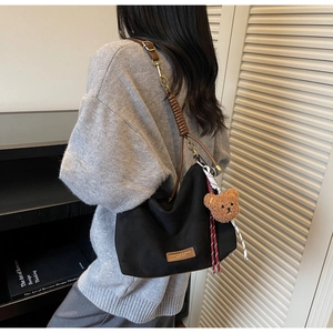 Vue arrière du sac cabas rétro noir avec anses en cuir marron et pendentif ours mignon