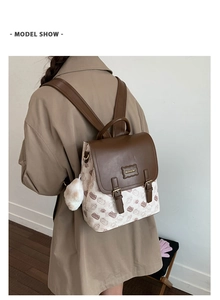 Détail d'un sac à dos vintage en toile avec motif de chat et rabat en cuir marron