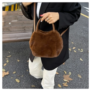 Detail of dark brown faux fur handbag worn with an elegant black blazer outfit
