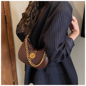 Détail du sac demi-lune marron foncé avec fermoir doré et chaîne en métal élégante