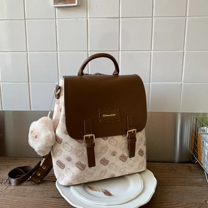 Détail d'un sac à dos crème avec motifs chats et porte-clé alpaga en peluche mignon