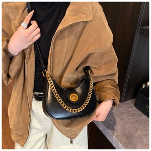 Dettaglio borsa hobo nera con grossa catena dorata e chiusura a girello in metallo