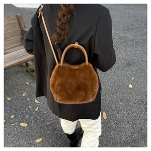 Detail of soft brown faux fur handbag texture with contrasting leather handles and strap