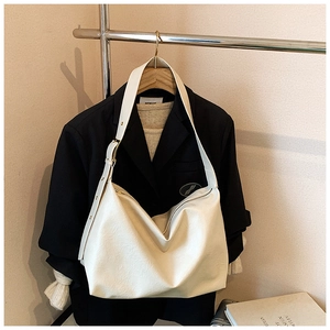 Macro shot of cream soft leather texture and adjustable strap buckle on tote bag