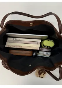 Macro detail of brown tote bag interior storage capacity with zipper pocket and items