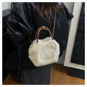 Detail of soft cream faux fur handbag with brown leather straps shown on model