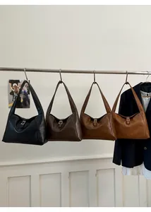Close-up of four minimalist hobo bags in assorted leather colors with metal buckles