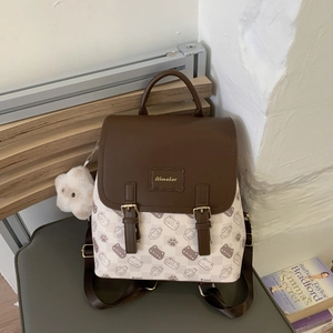 Détail d'un sac à dos pour femme avec motifs de chats et pendentif ours en peluche mignon