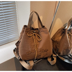 Detail of dark brown canvas bucket backpack with YOU I BEAR embroidery and drawstring