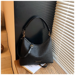 Close-up of black woven leather texture and gold hardware on hobo shoulder bag