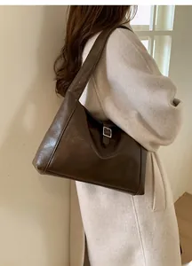 Detail of a dark brown vintage crescent bag showing the wide strap and silver metal buckle
