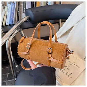 Detail showing brown cylinder barrel bag with premium PU leather and suede patchwork design