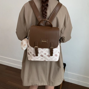 Détail d'un sac à dos élégant à motif chat avec rabat marron et pompon en peluche