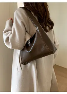 Close-up of the vintage brown leather shoulder bag with metallic buckle detail