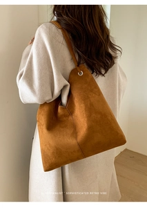Detail einer großen braunen Wildleder-Tote-Bag mit silbernem Metallring am Schultergurt