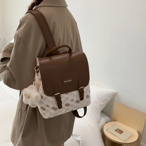 Détail du sac à dos montrant des finitions en cuir brun et toile à imprimé chat mignon