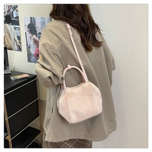 Pink faux fur handbag with crossbody strap shown in a lifestyle interior setting