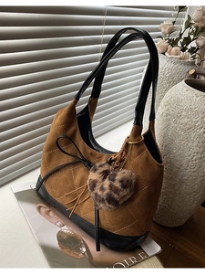 Brown suede underarm bag with quilted stitching, black leather straps and heart charm
