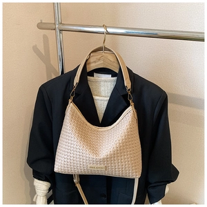 Detail of light beige woven hobo bag showing intricate texture and dual strap design