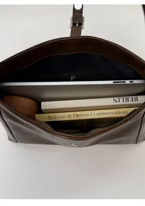 Top view of spacious interior of dark brown leather crescent bag showing daily essentials