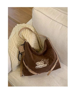 Detail view of large leopard print suede tote bag with cute cookie embroidery and charm