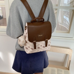Vue détaillée du dos d'un sac à dos à carreaux beige avec imprimés chats et lanières cuir