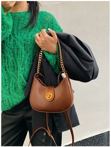 Dettaglio borsa hobo marrone con manico a catena dorata e chiusura a girello rotonda