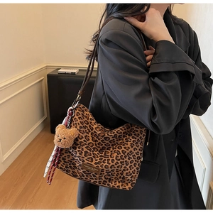 Close-up of leopard print tote bag with leather tag and cute yellow bear pendant