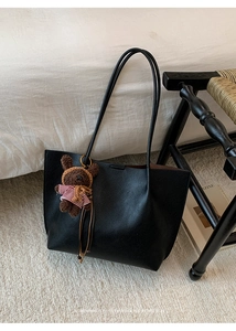 Black pebbled leather tote bag detail with cute bear charm and minimalist retro vibe