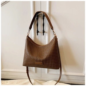Detail shot of the dark brown woven texture and adjustable strap on this chic hobo bag