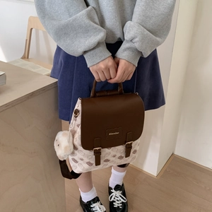 Détail du sac à dos vintage beige et marron à motif chat avec un pendentif alpaga doux