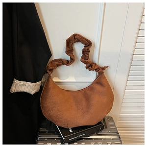 Detail of vintage brown suede dumpling bag with elegant scrunchie handle design