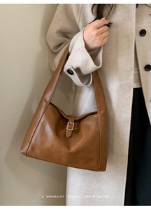 Detailed close-up of retro brown hobo bag featuring silver buckle and leather texture