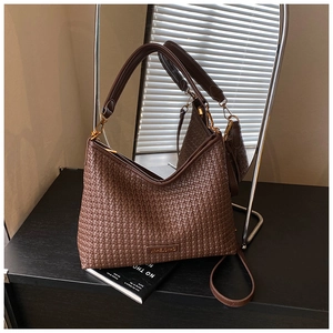 Detail of dark brown woven Hobo bag showing golden hardware and dual strap design