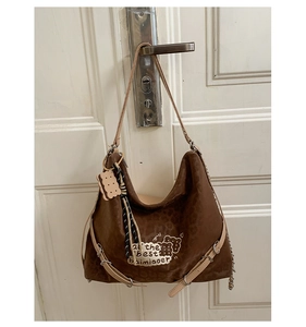 Close-up of brown leopard print shoulder bag featuring suede texture and charm