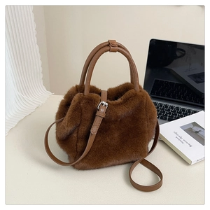 Close-up of brown faux fur texture and leather handle on stylish autumn winter handbag