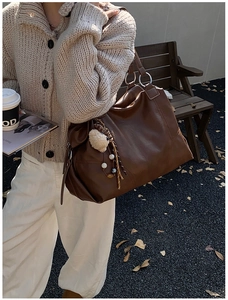Dettaglio della borsa tote marrone vintage con un grazioso ciondolo a forma di agnello