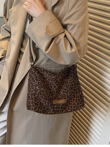 Leopard print tote bag with brown straps styled on a khaki trench coat for urban commute