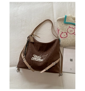 Close-up of leopard print canvas bag with beige strap and letter patch detail