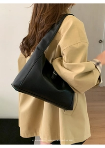 Minimalist black retro faux leather shoulder bag worn by model showing side profile