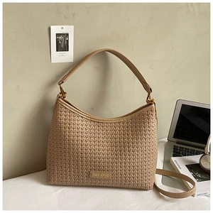 Detail of beige woven hobo bag with adjustable strap and chic urban lifestyle accessories